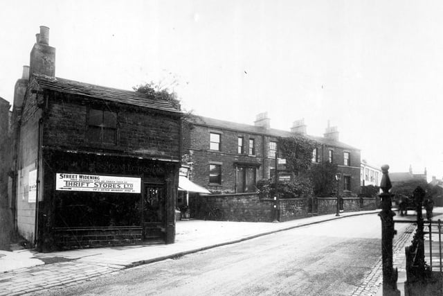 North Lane in October 1931.On the left is a former confectioners shop. Notice reads 'Street Widening, premises to be demolished. This business will be taken over by Thrift Stores ltd, next door (arrow pointing left) on or after June 15th'. Next, the shop blind can be seen, signs on pole say 'public telephone' and 'Hannam Fruit and Fish', this was for Suttill Hannam, greengrocer. Towards the right, white building which can be seen is the Lounge Cinema.