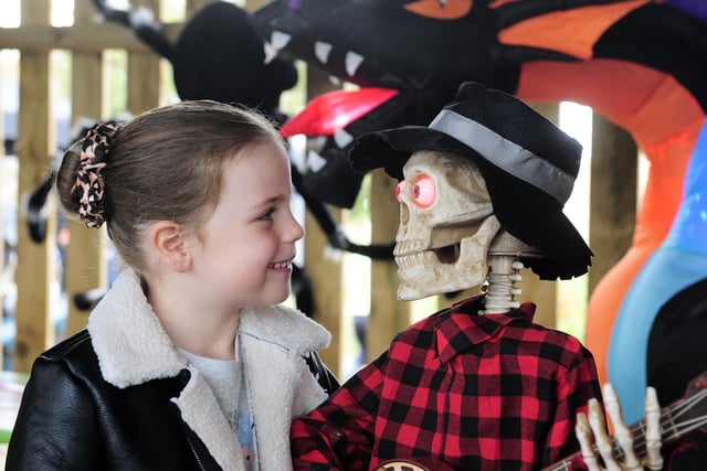 Ruby McLaughlin, five, gets a close look at one of the Halloween figures dotted around the farm