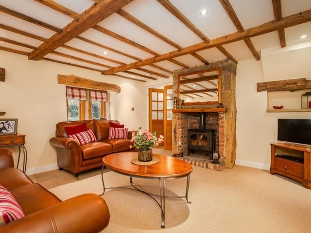 A cosy snug, with log burner and exposed beams to the ceiling.