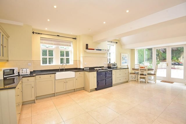 Fitted units with granite worktops, an AGA, and integrated appliances are all within the dining kitchen.