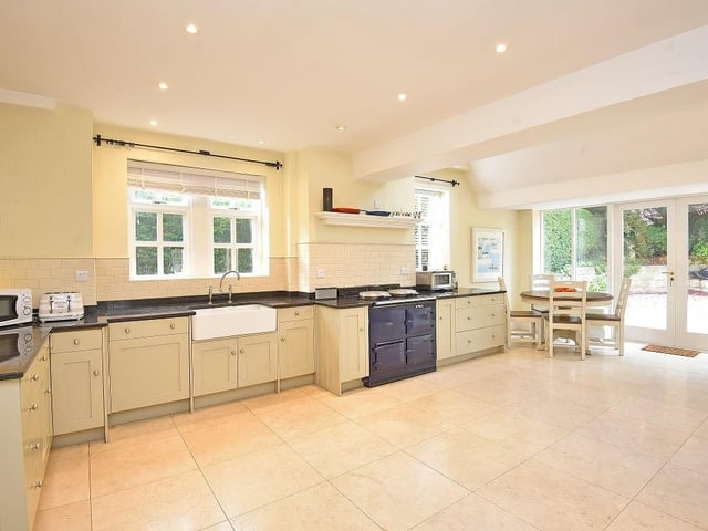 Fitted units with granite worktops, an AGA, and integrated appliances are all within the dining kitchen.