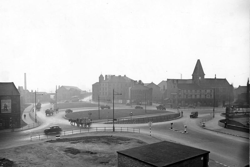 Marsh Lane roundabout from Duke Street in . A low brick building is in the foreground. Cars, lorries and two horse and carts are on the road. On the right the Palace Hotel (Melbourne Ales) can be seen on Kirkgate. Pictured in November 1945.