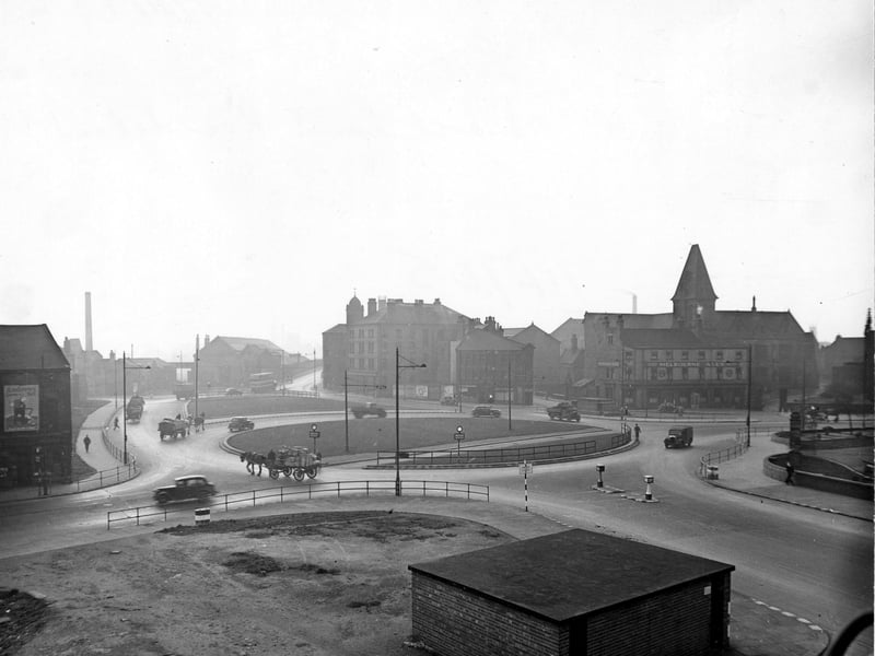 Marsh Lane roundabout from Duke Street in . A low brick building is in the foreground. Cars, lorries and two horse and carts are on the road. On the right the Palace Hotel (Melbourne Ales) can be seen on Kirkgate. Pictured in November 1945.