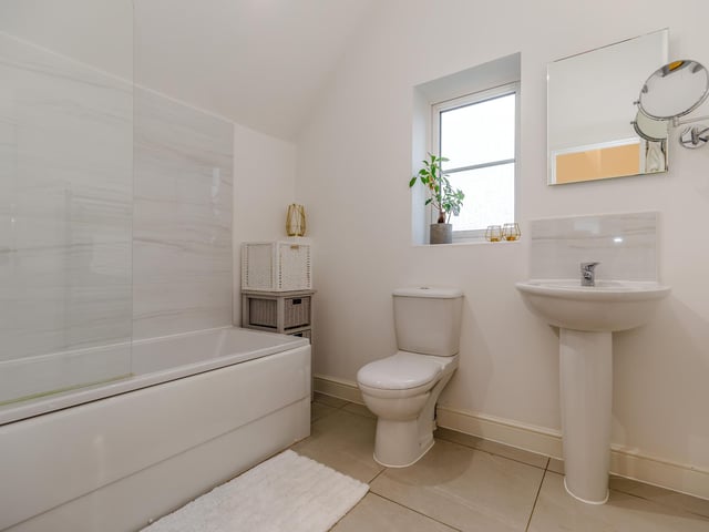 A bathroom in neutral colours, with heated towel rail.