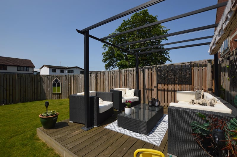 The back garden has composite decking seating space with a pergola above, plus a further Indian stone patio.