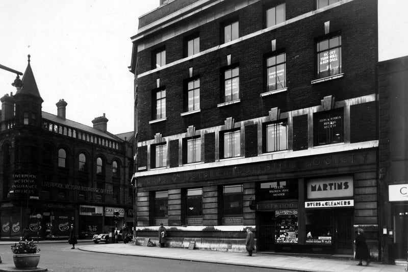 The Headrow at the junction with Albion Street pictured in May 1951. Premises shown are (on Albion Street), The Liverpool Victoria Insurance Co.; The Chocolate Box, confectioners; W.E Edgerton, pastry cook; Carl & Co., gowns. On the right (on The Headrow) are; The Leeds & Holbeck Building Society; G. Eastwood, tobacconist and Martins Ltd., dyers and cleaners.