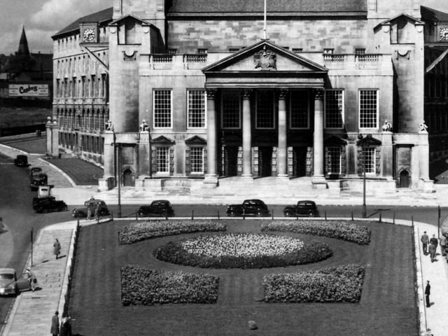 August 1949 and in view is Leeds Civic Hall with the Civic Gardens in the foreground, now the site of Millennium Square. Calverley Street runs to the left of the building and Portland Crescent to the right. Leeds Civic Hall, built in white portland stone dates from 1933.