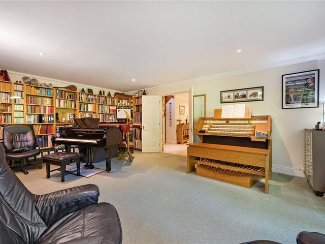 To either side of the main entrance hall is the spacious living room, with double doors to the garden, and the kitchen.