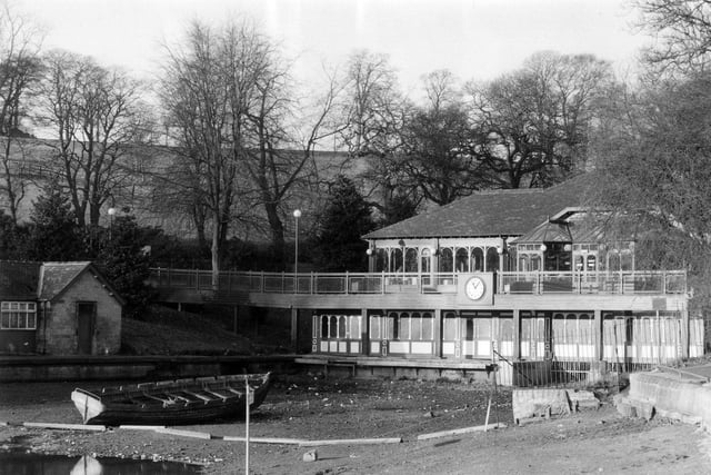 The Lakeside Café in Roundhay Park, possibly taken at the time that it was being converted into a café from the former boathouse. The edge of Waterloo Lake in front has been drained of water and a lone boat sits at the bottom.