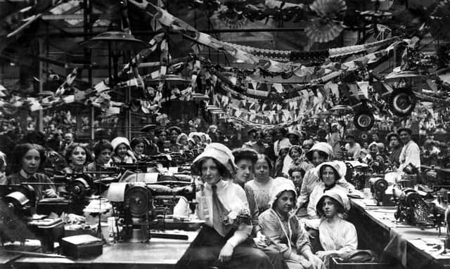 Staff seated at their Singer sewing machines at the firm of John Barran & Sons Limited, wholesale clothing manufacturers on Chorley Lane. The workplace was festooned with decorative bunting and paper chains, from which are suspended rosettes displaying the portrait of George V. The elaborate decorations are in celebration of his coronation which took place on June 22, 1911.