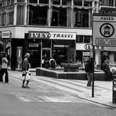 Lands Lane precinct at the corner with Albion Place in April 1979. The fountain and precinct were opened on April 12, 1972, by Environment Secretary Peter Walker. From the left, on Albion Place, shops include Bailey's, Nicola Anne, Willerby, Royce Manshop Ltd at number 27, Brandon House Ltd jeweller's at 28 and Ivey Travel at number 6 Lands Lane. A sign in the foreground informs that Lands Lane is a paved zone with vehicle restrictions.