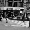 Lands Lane precinct at the corner with Albion Place in April 1979. The fountain and precinct were opened on April 12, 1972, by Environment Secretary Peter Walker. From the left, on Albion Place, shops include Bailey's, Nicola Anne, Willerby, Royce Manshop Ltd at number 27, Brandon House Ltd jeweller's at 28 and Ivey Travel at number 6 Lands Lane. A sign in the foreground informs that Lands Lane is a paved zone with vehicle restrictions.