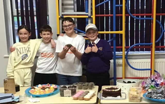 Twins Lola and Ted Wilson, joined by classmates Isaac Dixon and Charlie Weaver, proudly sell their homemade treats at the school’s charity bake sale.