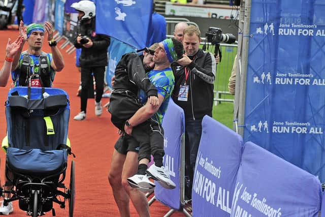 Kevin Sinfield carries teammate Rob Burrow over the finish line at the inaugural marathon. Picture: Steve Riding.