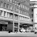This view from June 1967 looks across The Headrow from the junction with Albion Street. To the left is Headrow House with shops on the ground floor including B.O.A.C. at number 34 and Vallance's radio and television engineers. On the right is Lewis's department store. Originally Woodhouse Lane continued from Merrion Street, running between these two buildings to join The Headrow. The area was later widened to accommodate the St John's Centre and Dortmund Square.