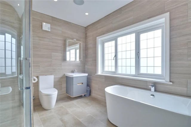An impressive, luxuriously appointed four piece family bathroom incorporating a free standing bath tub, separate shower enclosure and basin inset to vanity storage with high gloss illuminated and heated vanity mirror/cabinet. Modern ceramics floor to ceiling and the Sonos music system and underfloor heating.