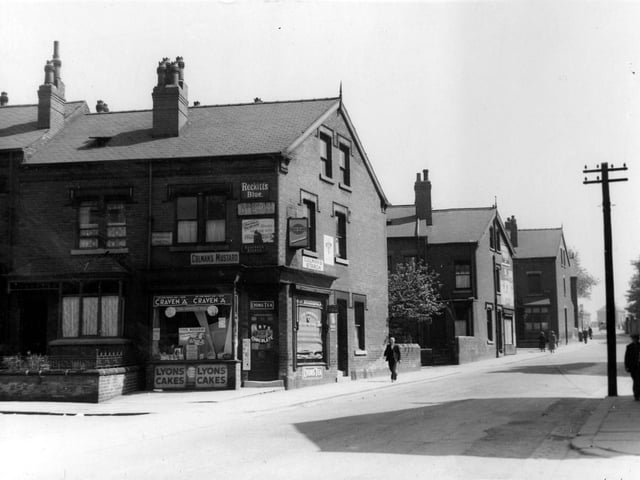 Shop on the corner of Seaforth Avenue and Foundry Lane (renamed Foundry Approach) in June 1939. Shows advertising signs and people passing by. Advertising signs for Colmans Mustard, Colmans Starch, Reckitts Blue, Craven A, Lyons Cakes, Lyons Tea, Frys Chocolate, Gold Flake, Bournville Cocoa, Woodbines and Stork Margarine.