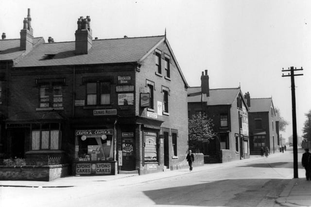 Shop on the corner of Seaforth Avenue and Foundry Lane (renamed Foundry Approach) in June 1939. Shows advertising signs and people passing by. Advertising signs for Colmans Mustard, Colmans Starch, Reckitts Blue, Craven A, Lyons Cakes, Lyons Tea, Frys Chocolate, Gold Flake, Bournville Cocoa, Woodbines and Stork Margarine.