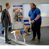 Sir Stephen Timms MP with Support Dogs trainer Joe Dickinson and trainee support dog Biscuit