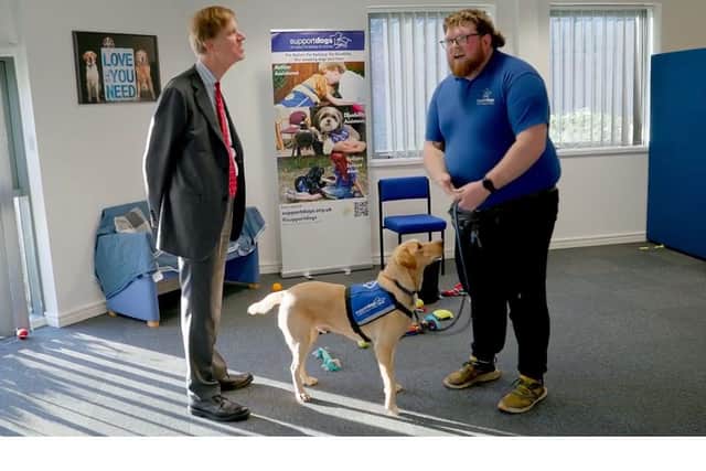 Sir Stephen Timms MP with Support Dogs trainer Joe Dickinson and trainee support dog Biscuit