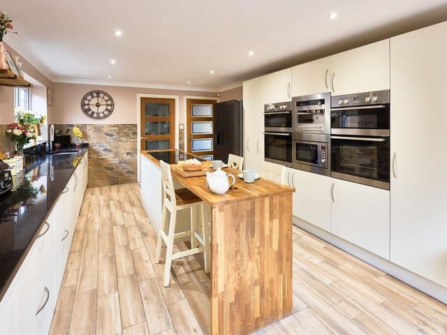 The kitchen has a calming modern country aesthetic and is set around a central island which houses the induction hob and doubles up as a breakfast bar for enjoying a morning coffee.