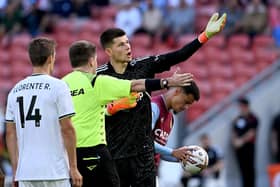 POOR SHOW - Illan Meslier points out the big screen footage that showed referee Adam Kersey that he had actually not seen a handball by Leeds United's Tyler Adams in the first half against Aston Villa. Pic: Getty