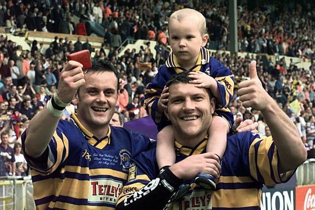 Try scorers Francis Cummins, left and Barrie McDermott celebrate with McDermott's son Billy, who was Rhinos' matchday mascot.
