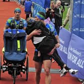 Kevin Sinfield carries Rob Burrow over the finish line of the Leeds marathon. Picture by Steve Riding.