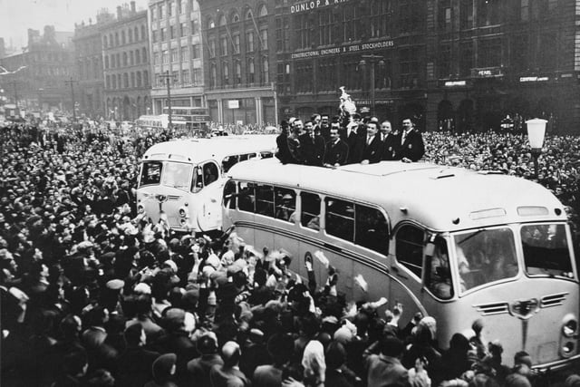 Through cheering crowds, a coach brings the Leeds Rugby League players and the Challenge Cup they won to Leeds Town Hall in May 1957. They beat Barrow 9-7 at Wembley in front of a crowd of 76,318.