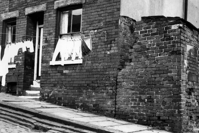 Washing hangs across Viscount Street in August 1965. An outside toilet block can be seen on the right edge. This area was redeveloped after slum clearance with the North West Leeds Working Men's Club now occupying this site.