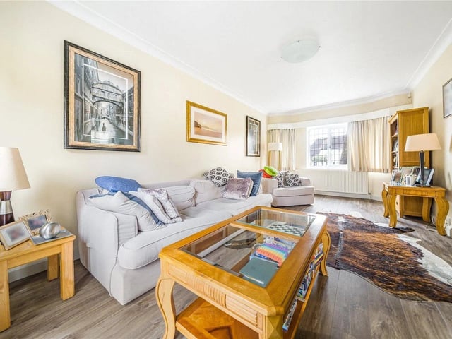 The elegant lounge has a feature fireplace and patio doors leading out to the rear garden.