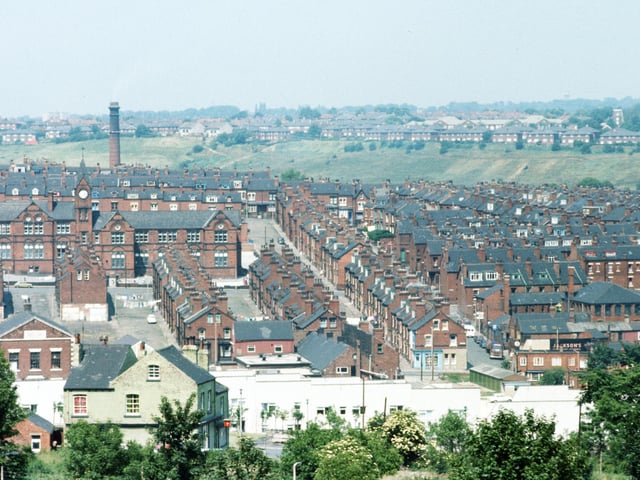 Woodhouse taken from Leeds University Engineering Department, centred on Quarry Street. Quarry Mount Primary School is on the left at the junction with Cross Quarry Street, with Bolland Street, Thomas Street and Quarry Place running down below it towards Woodhouse Street. Moving right, Christopher Road runs parallel to Quarry Street, with the Glossops and Beulahs leading off it. The chimney of the Meanwood Road Refuse Destructor is seen in the background, left, while in the distance on the right are houses on Potternewton Crescent.