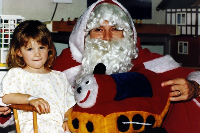 Killingbeck Hospital patient Jodie Townsend is bowled over by cricketer Martyn Moxon who was playing the role of Father Christmas on the children's ward in December 1991.