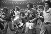 Mick Harrison, accompanied by jubilant Leeds fans, takes the Challenge Cup on a lap of honour at Wembley in 1978. Picture by Steve Riding.