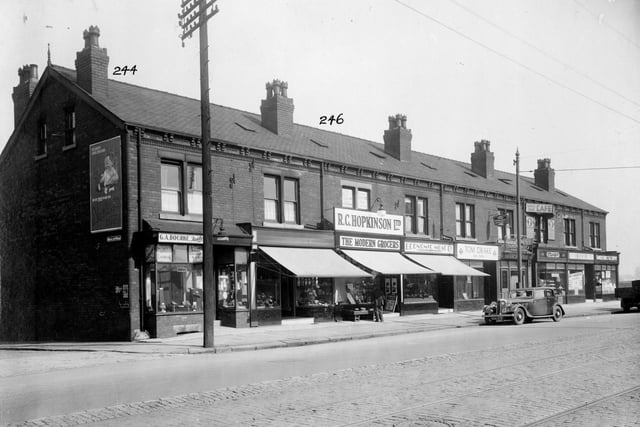 York Road in September 1935 On the left is Nickleby Avenue, poster on wall for Mawes baby food. Going right, the shops are as follows, no.239, G.A. Bourne, tailor. No.241, sweet shop, 243 R.C. Hopkinson 'The Modern Grocers', No.245 Economic Meat Company, H. Sykes. No.247 Tom Drake, fried fish shop. No.249, branch of Leeds Permanent Building society. No.251 Mintys' bakery and cafe, signs advertise lunches or teas for 11d(5p). 253 Harry Heslewood, gents hairdresser. Last in the row, no.255 Farmers Direct Egg Supply shop.