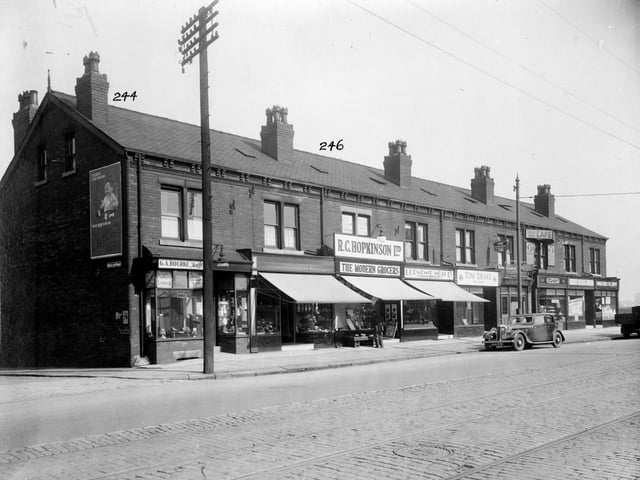 York Road in September 1935 On the left is Nickleby Avenue, poster on wall for Mawes baby food. Going right, the shops are as follows, no.239, G.A. Bourne, tailor. No.241, sweet shop, 243 R.C. Hopkinson 'The Modern Grocers', No.245 Economic Meat Company, H. Sykes. No.247 Tom Drake, fried fish shop. No.249, branch of Leeds Permanent Building society. No.251 Mintys' bakery and cafe, signs advertise lunches or teas for 11d(5p). 253 Harry Heslewood, gents hairdresser. Last in the row, no.255 Farmers Direct Egg Supply shop.