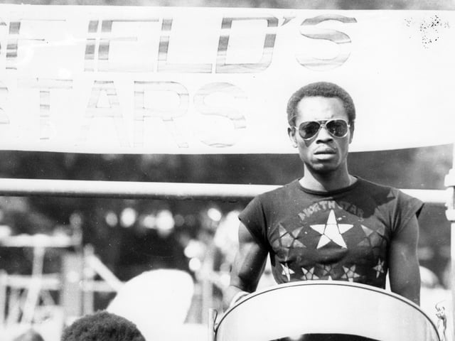A Pan player of Huddersfield's North Stars Steel Band, here for the 13th Leeds West Indian Carnival. The photograph has been taken in Potternewton Park, the assembly point for the bands, troupes and individuals taking part in the carnival procession on August Bank Holiday Monday, 1980.