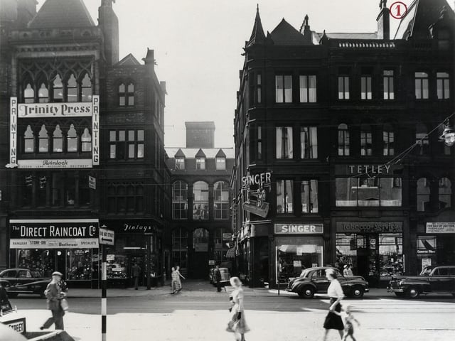 The south side of Boar Lane looking down White Horse Street in July 1955. Many shops can be seen including Trinity Press Printers, The Direct Raincoat Co., Finleys tobacconists, Singers Sewing Machine shop, Tobacco Services and an Auction room.