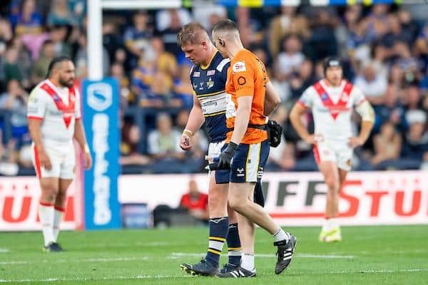 Rhinos' Tom Holroyd, pictured being helped off the field after taking a knock against St Helens two weeks ago, will miss a second successive game. Picture by Allan McKenzie/SWpix.com.