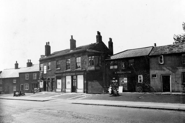 The Main Street, Seacroft premises formerly J.P. Burcham grocer and A. Broughton newsagent. Advertising boards outside shops for cigarettes, including Players and Wills' Woodbines. Two bicycles are outside the newsagents. Pictured in June 1936.