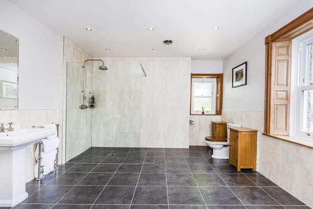 This palatial bathroom has a walk in shower, twin wash basins and a stand alone bath.