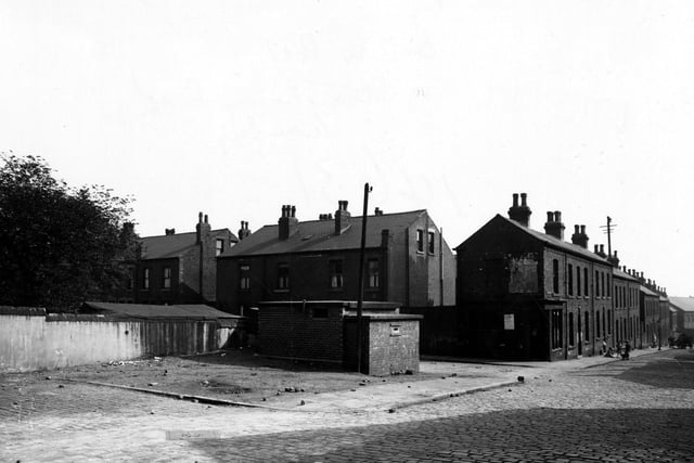 View of the Air Raid Warden's post on the corner of Strawberry Road and Barnet Mount. Children are playing further along the cobbled street. Pictured in September 1945.