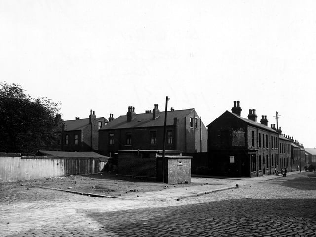 View of the Air Raid Warden's post on the corner of Strawberry Road and Barnet Mount. Children are playing further along the cobbled street. Pictured in September 1945.