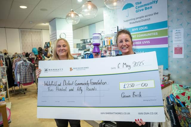 B&DWYW - SGB-28403 -Jenna from Barratt and David Wilson Homes (L) handing Lisa of Wakefield & District Community Foundation
