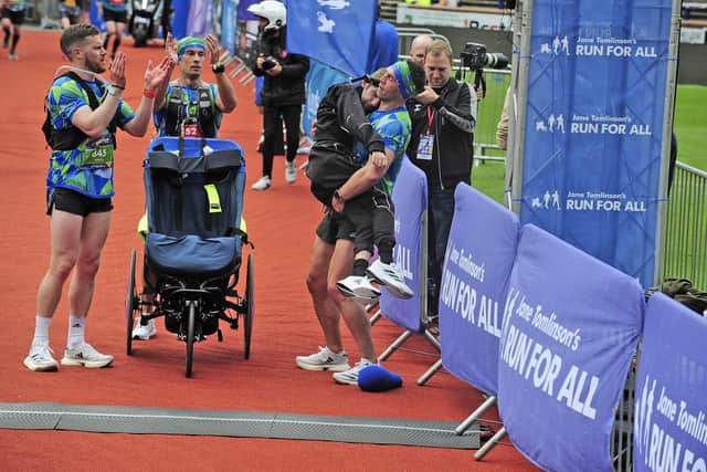 Kevin Sinfield carries Rob Burrow over the finish line of the marathon named in his honour. Picture by Steve Riding.