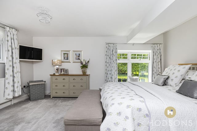 A spacious double bedroom with views of the garden.