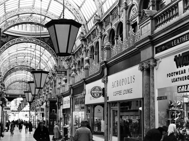 County Arcade looking in the direction of Vicar Lane in July 1982. Some of the shops & businesses seen include Saltaire Galleries, Waynes shoe shop, Acropolis Coffee Lounge and, at the right edge, Walco Footwear, Luggage and Leathergoods. The entrance to Queen Victoria Street is behind the women looking in the window of Saltaire Galleries, left of centre.