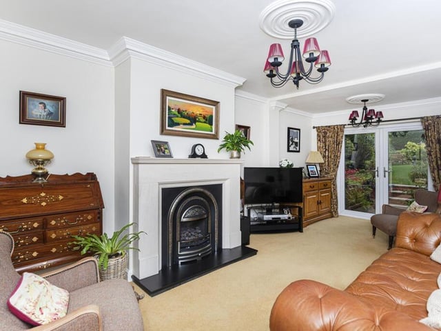 A stunning reception room with feature fireplace has patio doors leading to the garden and patio.