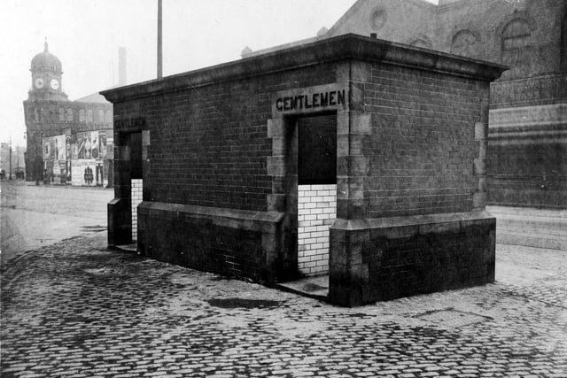 A gentlemen's urinal on Hunslet Road pictured in April 1927. . Advertising hoardings can be seen on the right with the buildings and clock tower of Alf Cooke, printers also visible.