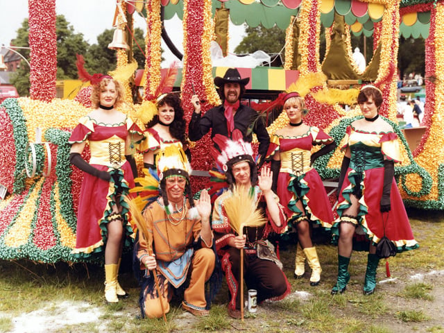 Proud members of Lewis's 'Fells Wargo Railway Co.'(A humorous play on words with reference to 'Wells Fargo', of course). They pose in their colourful costumes in front of the spectacular decorated steam engine of the American West. This was Lewis's entry to the 7th Lord Mayor's Parade for which it won Best Overall Entry. It took over 20,000 ribbon parcel bows to decorate the float. Pictured in June 1980.
